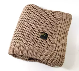 Duży, beżowy koc o grubym splocie